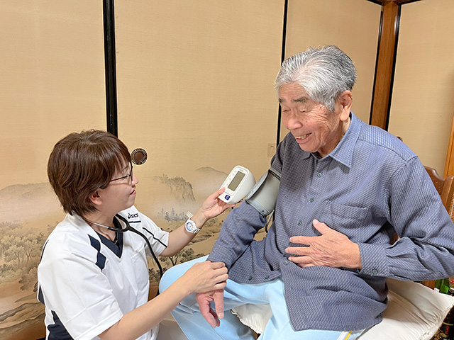 画像：血圧を測る職員と笑顔の入居者