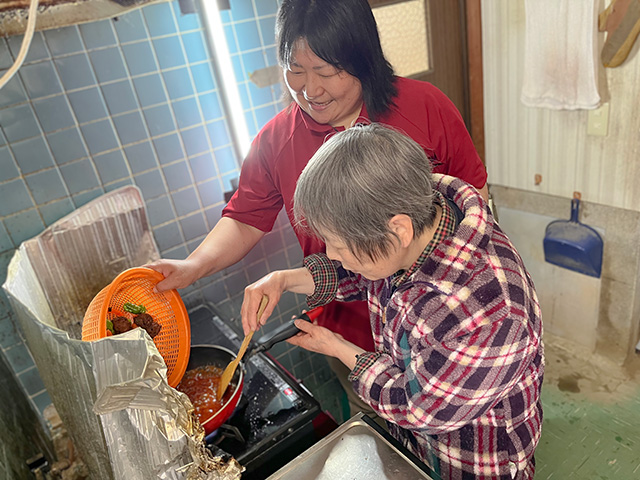 画像：職員と料理をする女性入居者